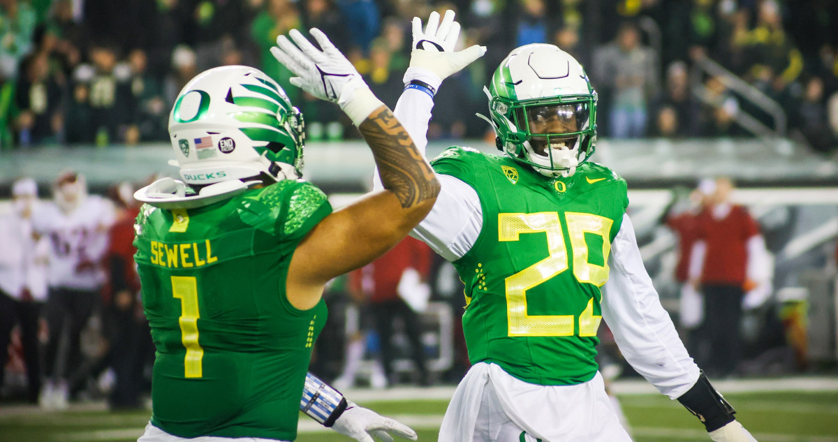Adrian Jackson (29) high-fives Noah Sewell (1) in a game against Washington State at Autzen Stadium.